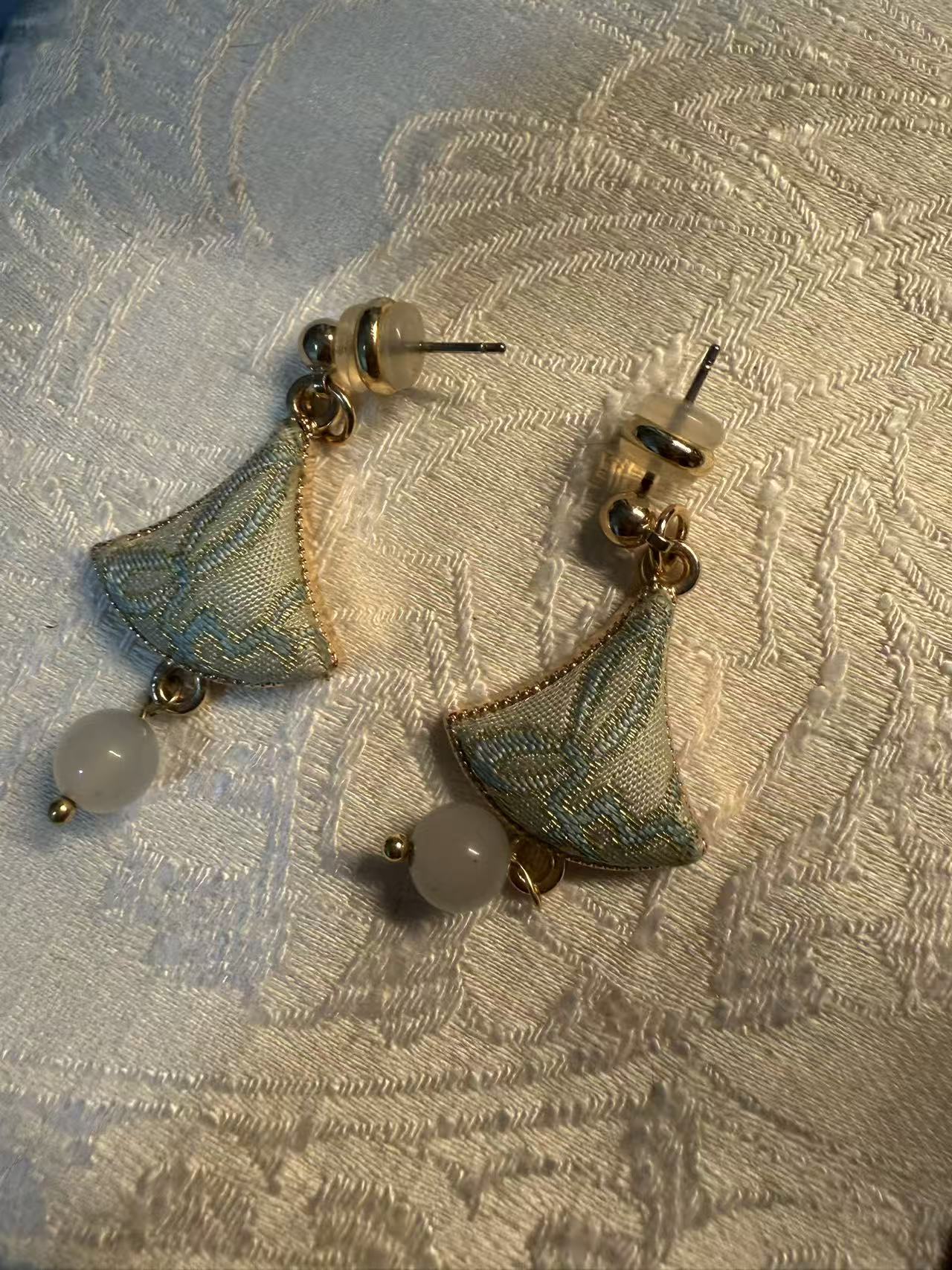 Green Songjin ear-rings worn in a traditional Chinese interior